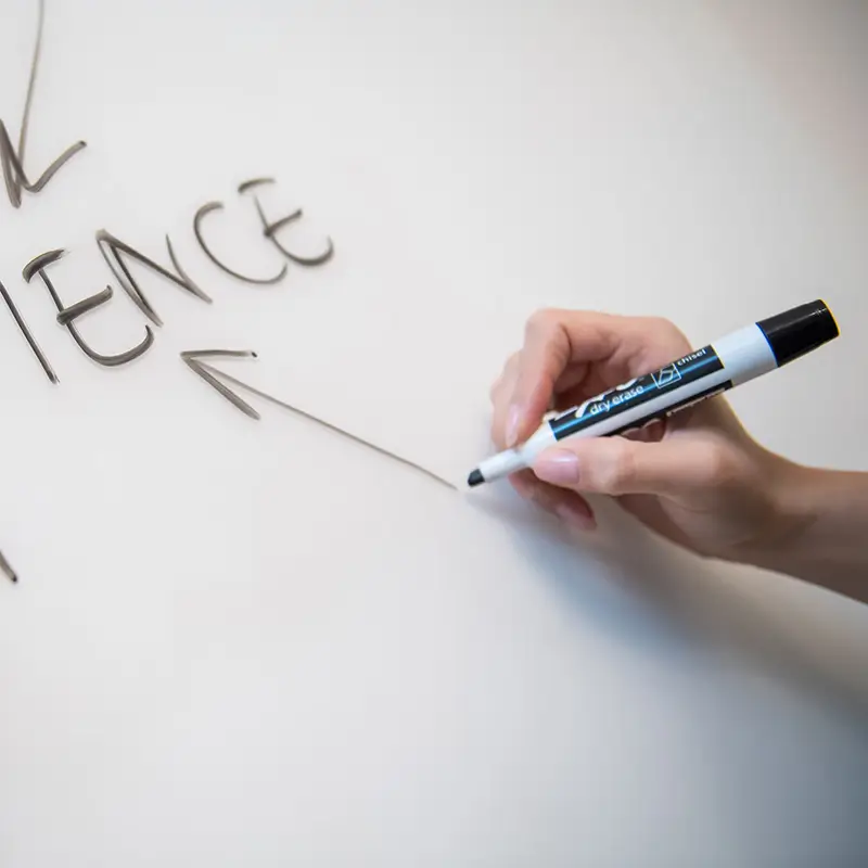 somebody writing on whiteboard, as if in a workshop
