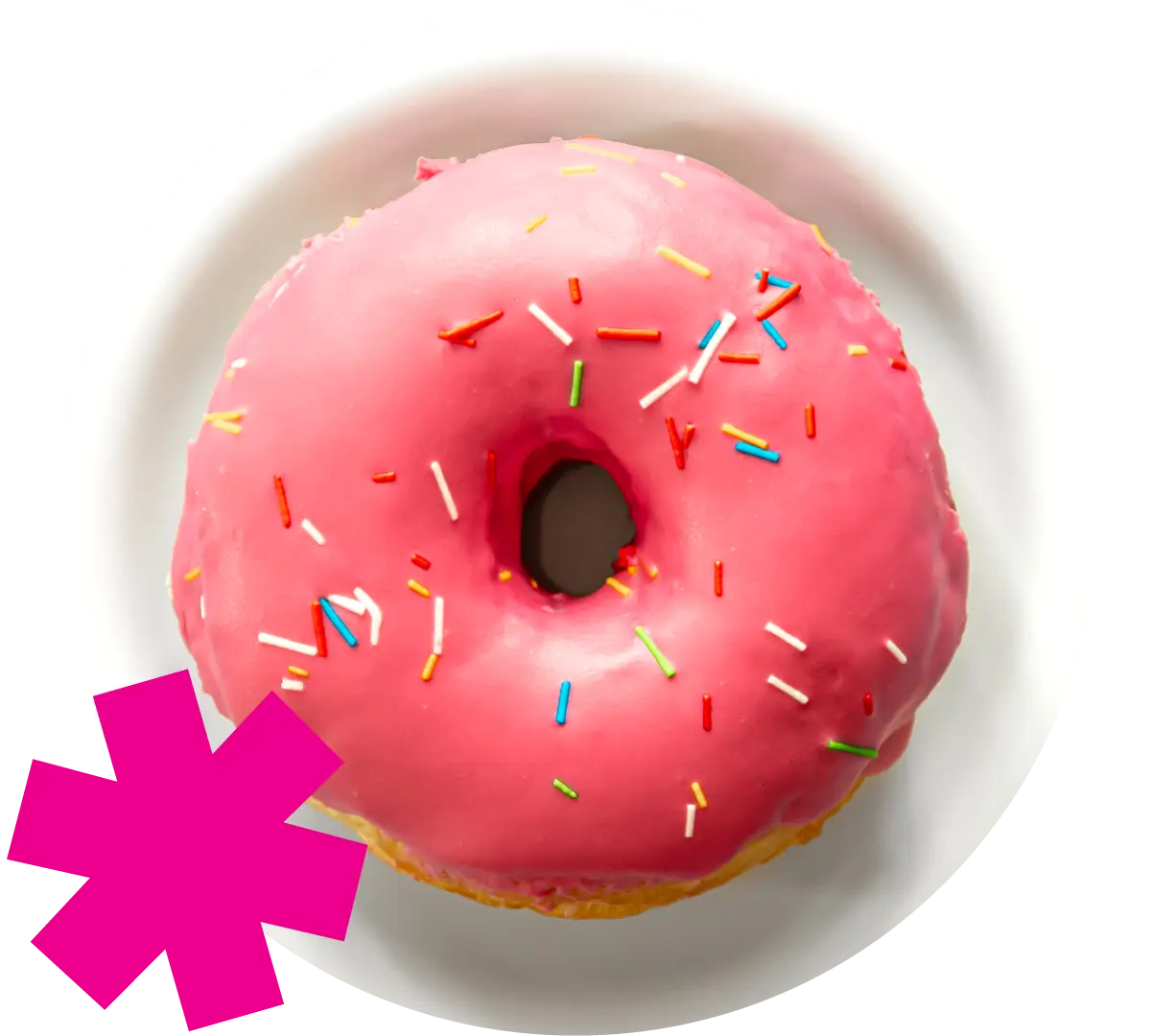 Pink donut with sprinkles on white plate